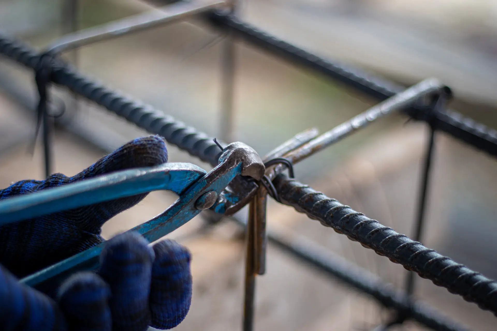 The hands of construction workers using using steel wire to bind steel bars.